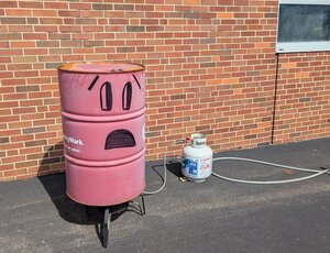 A pink oil barrel with a worried face drawn on it in permanent marker.