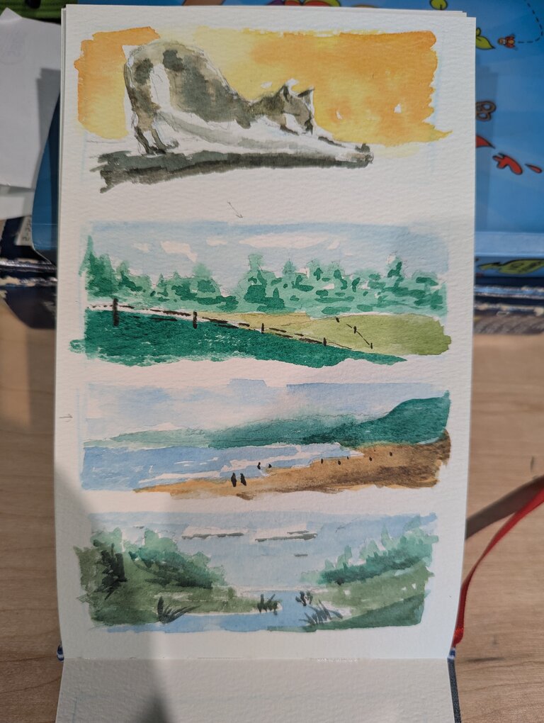 Four bookmark sized paintings. The first is a cat stretching. The second is a green field with a fence running into the distance. The third is a beach with green hills surrounding a beach with people in the distance. The fourth is a stream with two small hills running down to the water.