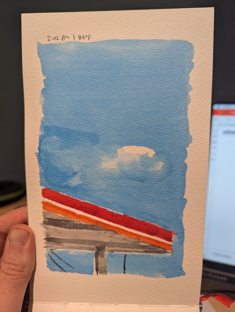 A bright red gas station roof against a blue sky.