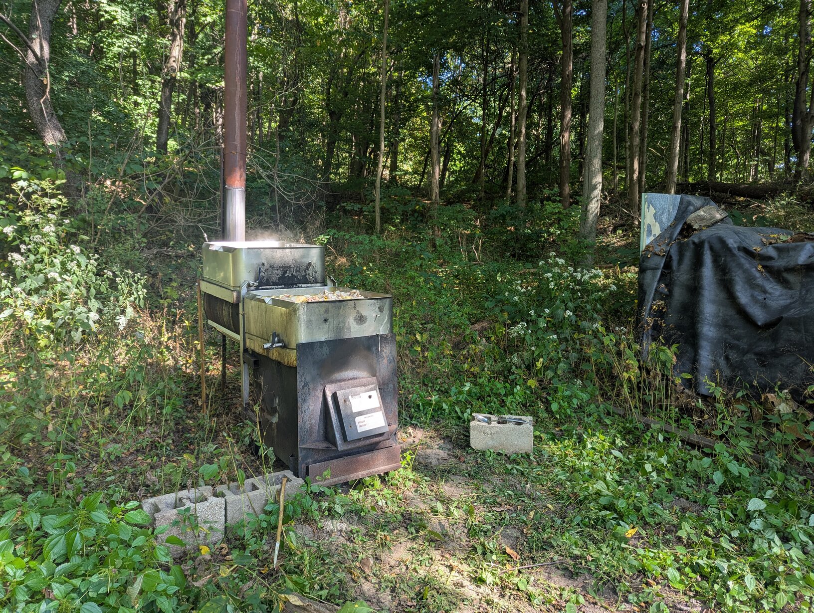 A large cast iron fireplace with two stainless steel stock pans on top.