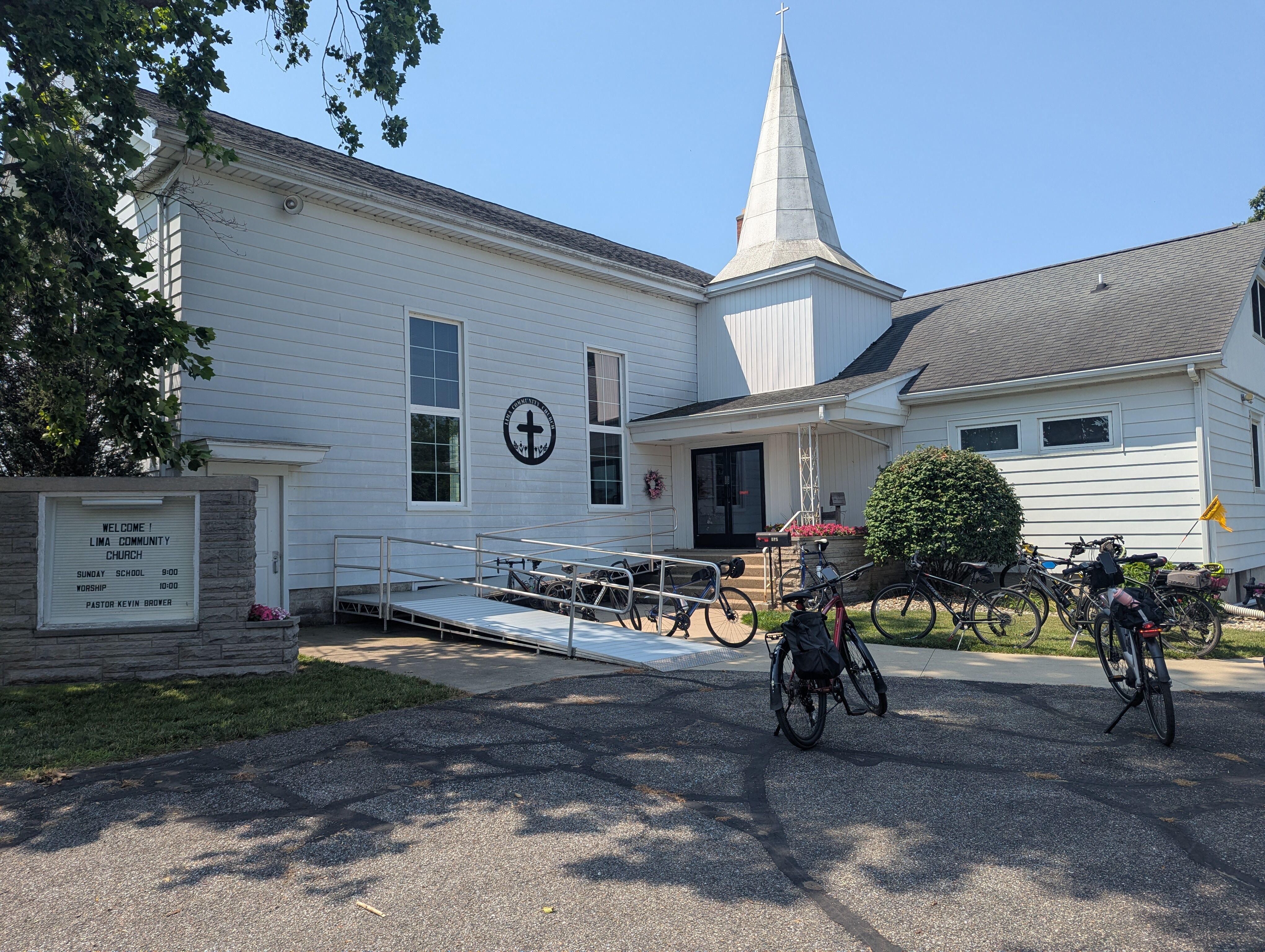 A white church with bicycles parked out front.