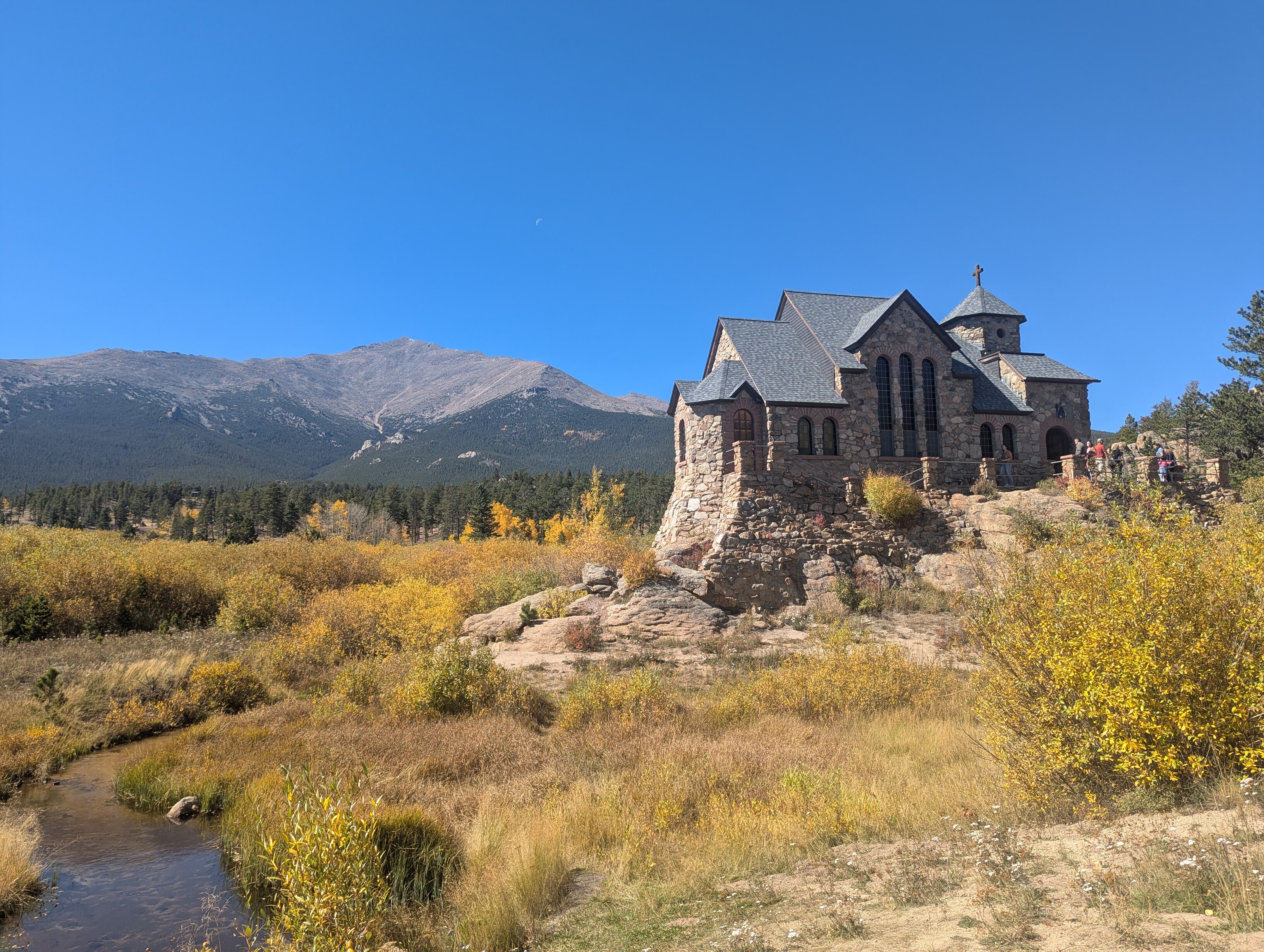 A small stone church sits on a rock. A large mountain is in the distance.